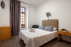 a bedroom with a bed with two stuffed animals on it at Guest House Porto Clerigus in Porto