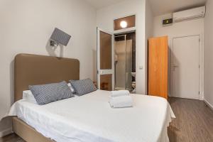 a bedroom with a large white bed with blue pillows at Guest House Porto Clerigus in Porto