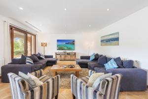 a living room with blue couches and a table at Villa Coloma in El Port