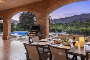 an outdoor dining room with a table and a fireplace at Villa Coloma in El Port