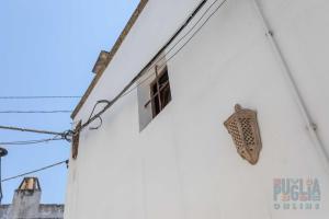 een raam aan de zijkant van een wit gebouw bij Casetta Centro Storico Puglia On line in Alliste