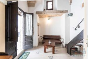 een woonkamer met een zwarte deur en een bank bij Casetta Centro Storico Puglia On line in Alliste
