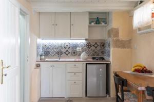 een keuken met witte kasten en een fruitschaal bij Casetta Centro Storico Puglia On line in Alliste +15 foto's