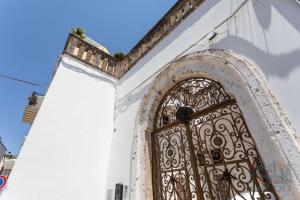 een deur naar een wit gebouw met een poort bij Casetta Centro Storico Puglia On line in Alliste