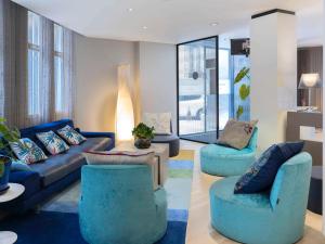 una sala de estar con sofás y sillas azules en Mercure Nice Centre Grimaldi, en Niza