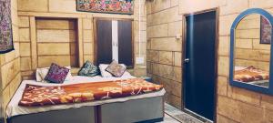 a bedroom with a bed in a room with a mirror at Thar Accent Hostel in Jaisalmer