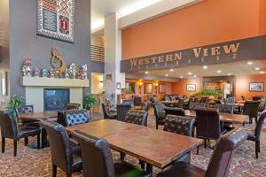 Best Western Plus Inn of Williams في ويليامز: غرفة طعام مع طاولات وكراسي في مطعم