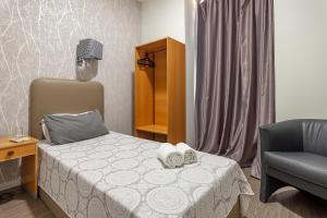 a small bedroom with a bed and a chair at Guest House Porto Clerigus in Porto