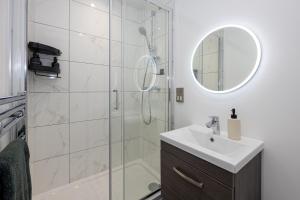 een badkamer met een douche, een wastafel en een spiegel bij Oscar House - 2 Bed City Apartment with Free Parking in Manchester