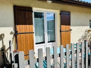 ein Haus mit einer weißen Tür und einem Zaun in der Unterkunft Studio avec terrasse privative in Pessac