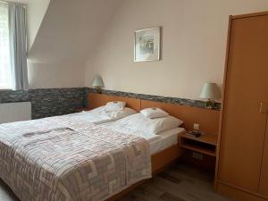 a hotel room with a bed and a nightstand with a bed sidx sidx sidx at Hotel Haus Martens in Hannover