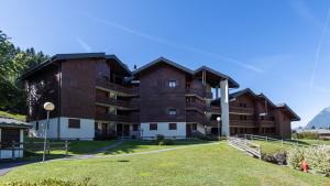 a large brown building with a grassy field in front of it at OURSONS 4 - 30 - Superbe appt 6 pers in Morillon