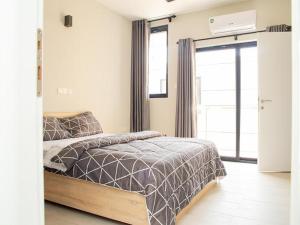 ein Schlafzimmer mit einem Bett und einem großen Fenster in der Unterkunft Furnished apartment for long and short stay in Accra