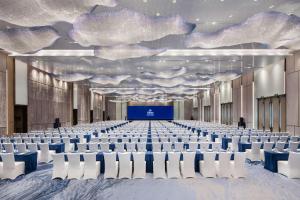 una sala conferenze con sedie bianche e un soffitto pieno di nuvole di Hilton Quanzhou Riverside a Quanzhou