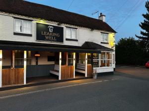 un edificio con una señal que lee bien el aprendizaje en Leaking Well, Dunhampton, en Stourport