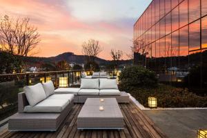 a rooftop patio with couches and a table and a building at Hilton Ningbo Dongqian Lake in Ningbo