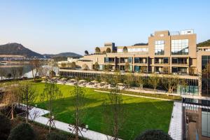 a park in front of a building with a lawn at Hilton Ningbo Dongqian Lake in Ningbo