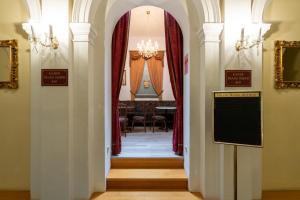 un pasillo que conduce a un comedor con cortinas rojas en Hotel-Zimmer direkt am See, en Gmunden