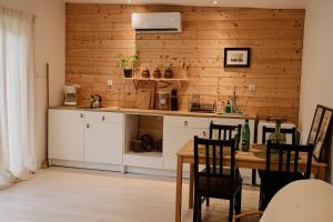 cocina con armarios blancos y pared de madera en Strefa medytacji, en Wólka