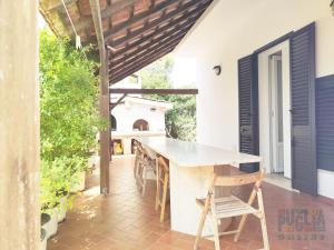 トッレ・サン・ジョヴァンニ・ウジェントにあるVilla di Nescoの家の中庭のテーブルと椅子