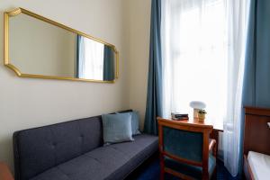 sala de estar con sofá y espejo en Hotel-Zimmer direkt am See, en Gmunden