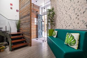 a living room with a blue couch and a staircase at Guest House Porto Clerigus in Porto