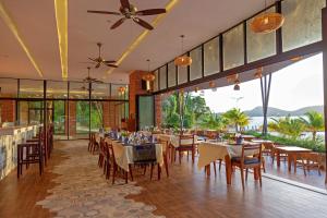 un restaurante con mesas, sillas y ventanas en Pearl Beach Resort & Spa, en Koh Rong Sanloem