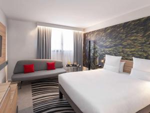 a hotel room with a bed and a chair at Novotel Blois Centre Val De Loire in Blois