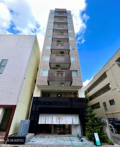 東京的住宿－KIN HOTEL，一座高大的建筑,旁边设有阳台