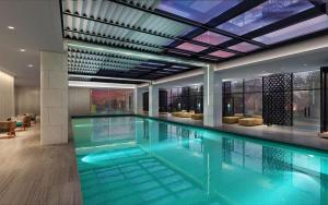 a swimming pool in a building with a ceiling at Hilton Taizhou in Taizhou