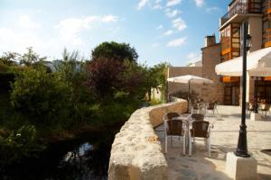 a patio with tables and chairs next to a river at Hotel Vila do Val in Ferreira