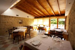 a dining room with white tables and chairs at Hotel Vila do Val in Ferreira