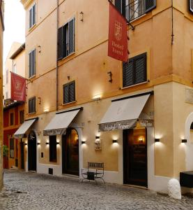 um edifício com um banco em frente a uma rua em Hotel Trevi - Gruppo Trevi Hotels em Roma