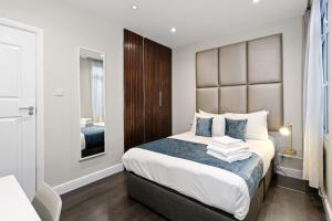 a bedroom with a large bed with a large headboard at Smart Stay Studio Flat in London