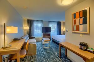 a hotel room with a bed and a desk at Homewood Suites by Hilton South Bend Notre Dame Area in South Bend