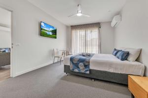 a bedroom with a bed and a tv on the wall at Comfort Suites Clubarham Golf Resort in Barham