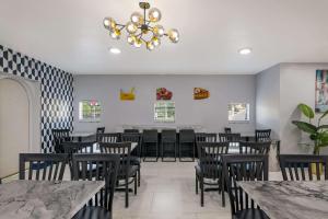 una sala da pranzo con tavoli, sedie e lampadario a braccio di Quality Inn & Suites Altamonte Springs Orlando-North a Orlando