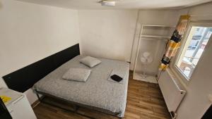 a small bedroom with a bed with two pillows on it at Gara de Nord-Banat-4-You in Bucharest