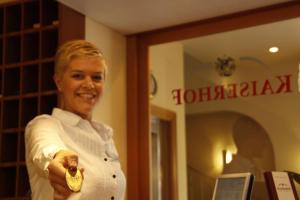 a woman is smiling while holding a gold object at Hotel Kaiserhof Wesel in Wesel