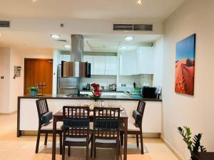uma cozinha e sala de jantar com mesa e cadeiras em The Bay Watchers Abu Dhabi 203NB em Abu Dhabi