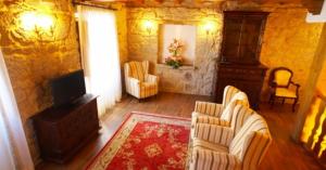 a living room with two chairs and a television at Hotel Vila do Val in Ferreira