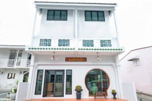a white building with a sign on it at ChomTique Hotel in Ban Chamun (2)