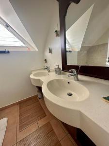 La salle de bains est pourvue de 2 lavabos et d'un grand miroir. dans l'établissement Appartement 2 à 6 personnes dans un magnifique complexe de Vacances à Sainte-Luce, à Sainte-Luce