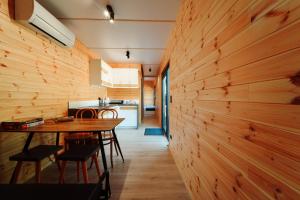 a kitchen and dining room with a wooden wall at Arche Siedlisko Gorodczyno in Narew