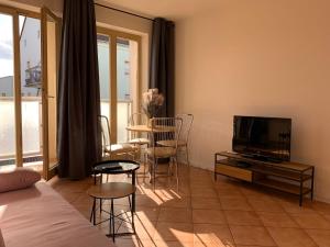 a living room with a television and a table and chairs at Apartamenty Staromłyńska in Szczecin