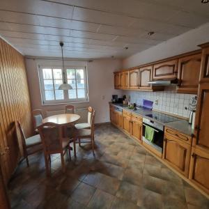 a kitchen with wooden cabinets and a table and chairs at DM Hotels & Apartments - Apartment Pfarrgasse 11 - in Küllstedt