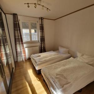 a room with two beds and a window at DM Hotels & Apartments - Apartment Pfarrgasse 11 - in Küllstedt