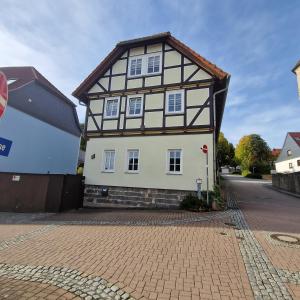 a white and black house on a street at Moritz Apartments - Apartment Pfarrgasse 11 - in Küllstedt