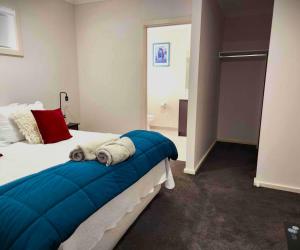 WindermereLucas One 2-bedroom apartment NBN Pets的一间卧室，床上铺着一条蓝色的毯子