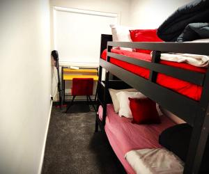 a bedroom with two bunk beds with red sheets at Lucas One 2-bedroom apartment NBN Pets in Windermere